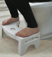 Space-saving folding toilet stool in white, with non-slip grip.