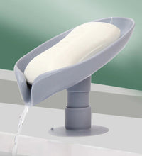 Self-draining soap holder in leaf shape for bathroom or kitchen.