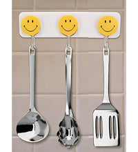 Pack of 3 self-adhesive smiley hooks for home use.