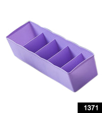 Clear plastic tray with dividers, used for storing beads and craft supplies.