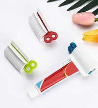 Toothpaste squeezer and holder stand for rolling tubes