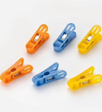 Durable non-slip plastic clips for cloth drying in bright colors.