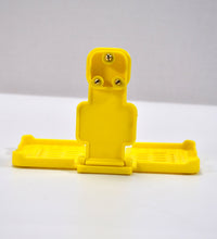 Yellow mobile holder for wall socket.