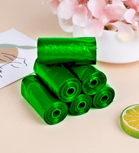 Green biodegradable trash bag rolls for household waste management.