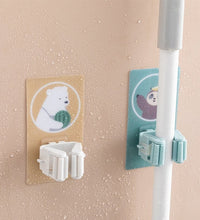 Magic sticker broom and mop holder for home storage solutions.